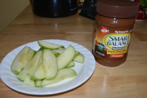 A perfect snack, sliced green apple and chocolate peanut butter spread.