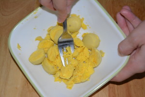 Mash egg yolks with a fork.