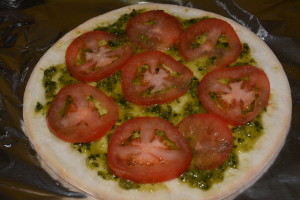 Sliced tomatoes layered on top of the pesto sauce.