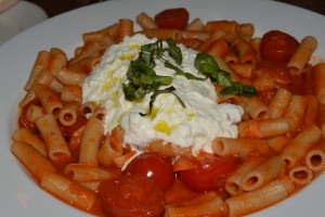 Gluten free rice pasta topped with a tomato sauce, basil, and burrata mozzarella.
