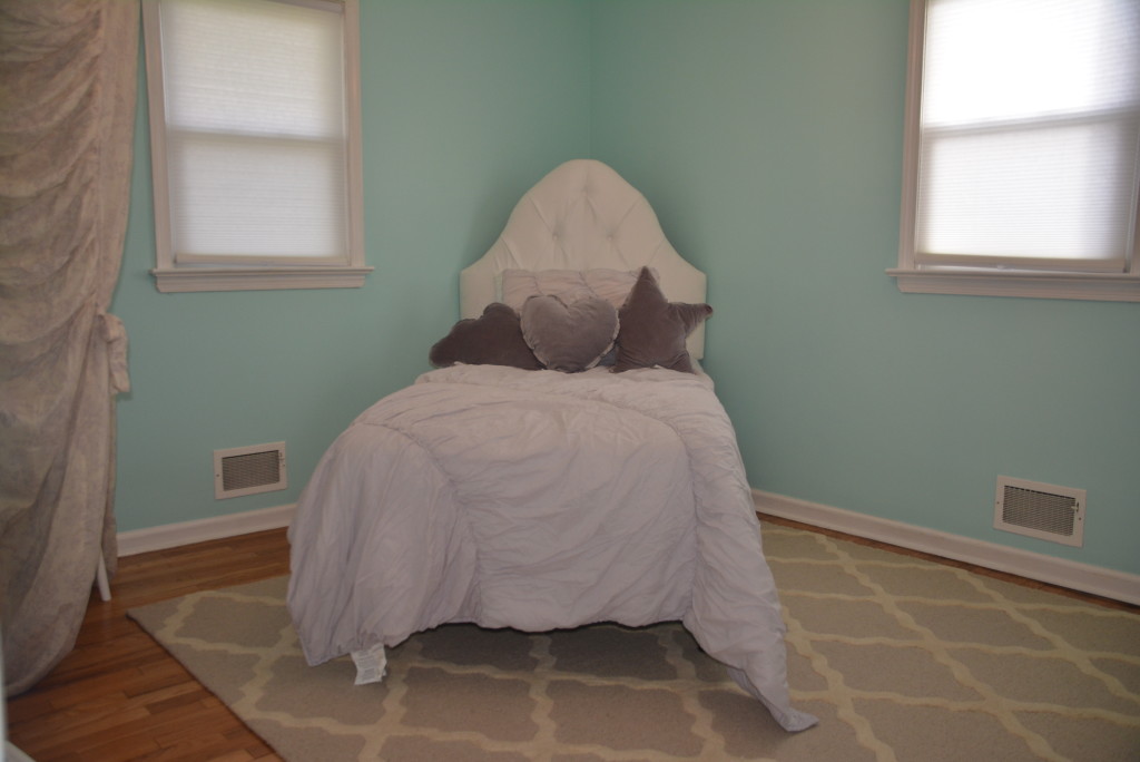 A big girl bed with all of the fixings including some hidden toddler rails on the sides.